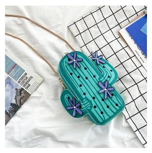 Detail of green cactus shaped PU leather bag with purple flower decor and gold chain strap