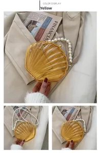 Détail du sac à main en acrylique en forme de coquillage avec poignée en perles