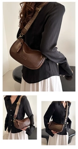 Détail du sac bandoulière en cuir marron foncé avec large sangle tissée et ferrures dorées