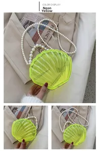 Détail de la pochette coquillage en acrylique jaune fluo avec poignée en perles et chaîne