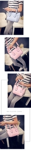 Detail of blue and pink cat-ear shaped handbags with golden feline logo accents