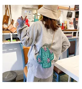Detail of creative green cactus-shaped PU leather crossbody bag with pink floral accents