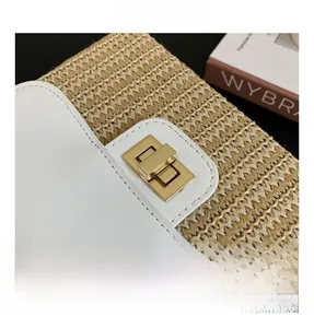 Detailed close-up of golden rectangular metal twist lock on a straw and leather bag