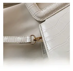 Macro detail of high-quality gold hardware hook on white crocodile pattern bag