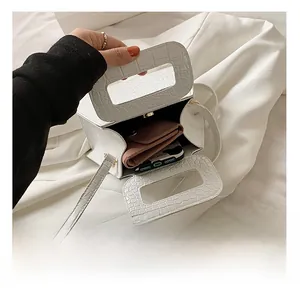 Detail view of white crocodile pattern triangle bag showing internal storage for wallet and phone