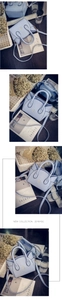 Detail of light blue cat-ear handbag with golden embroidery and adjustable strap