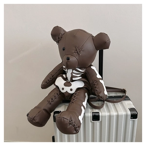 Detail of a dark brown leather teddy bear backpack with unique white bone pattern designs