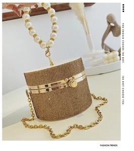 Exquisite cylindrical evening bag featuring sparkling rhinestones and a large pearl handle
