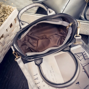 Silver winged handbag with cat motif featuring a spacious interior and golden hardware
