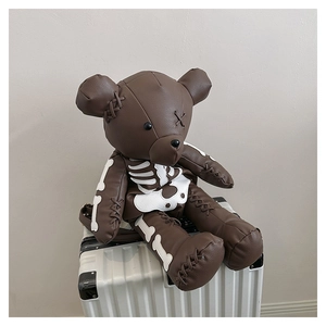 Detail of bear backpack showing textured leather and white skeleton bone patterns