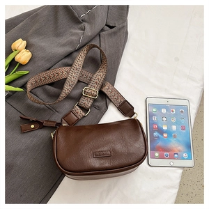 Sac bandoulière en cuir marron avec sangle tissée ethnique sur une veste