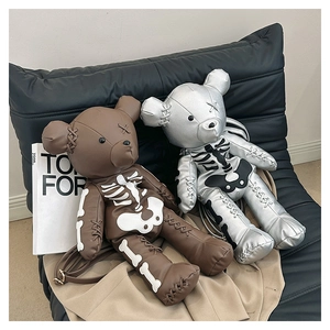 Detail of bear-shaped leather backpacks in brown and silver with skull bone prints