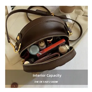 Close-up of brown round crossbody bag interior showing spacious storage for daily items