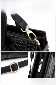 Close-up of golden hardware accessories and crocodile grain leather on women handbag