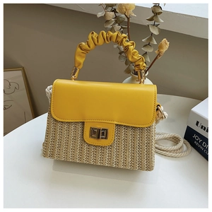 Detail of yellow woven handbag with cloud pleated handle and metallic square twist lock