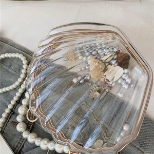 Gros plan sur pochette en acrylique en forme de coquillage avec perles et étoiles de mer
