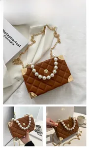 Macro shot of brown quilted box bag featuring pearl handle and gold chain details