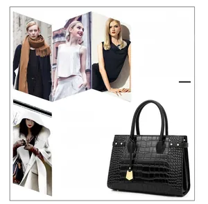 Detail of black crocodile texture leather handbag with gold metal pendant charm