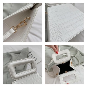 Detailed close-up of white crocodile pattern texture with golden metal hardware