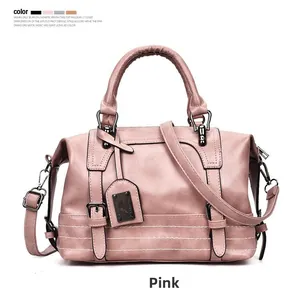 Detail of pink leather Boston bag with adjustable strap and decorative buckle straps