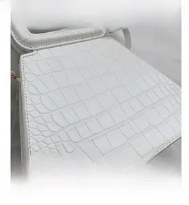 Close-up of white crocodile pattern synthetic leather with fine stitching detail