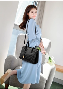 Fashionable black crocodile embossed tote bag with gold metal charm details and strap