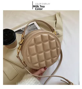 Detail of milk tea round crossbody bag with quilted chocolate block texture and gold hardware