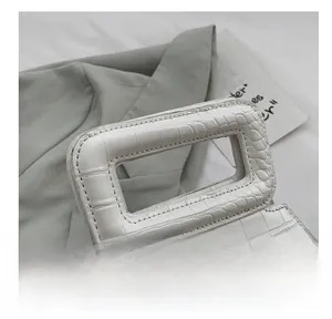 Detail shot of white crocodile embossed leather handbag with wide sturdy handle