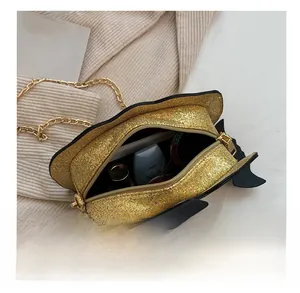 Internal capacity of gold sequin pumpkin chain bag showing lipstick and sunglasses