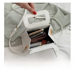 Internal capacity of white crocodile pattern handbag showing space for phone and wallet