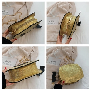 Detail view of gold sequin pumpkin bag with black bat wings and metal chain strap
