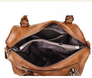 Macro view of the large capacity interior and multi-layer storage of the brown Boston bag