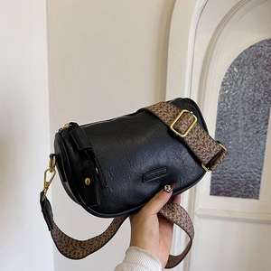 Sac bandoulière cylindrique noir minimaliste en cuir avec sangle tissée