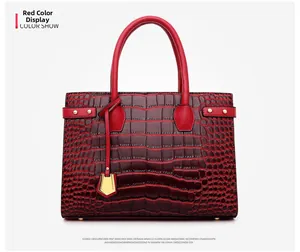 Detail view of red faux leather tote with shiny crocodile texture and metal rivets