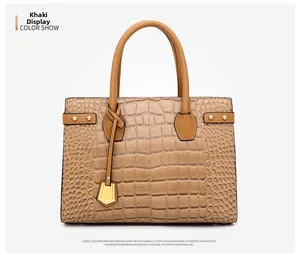 Macro view of khaki tote bag showing luxury crocodile embossed leather and gold hardware