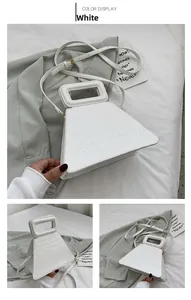 Detailed close-up of white trapezoid bag featuring embossed crocodile texture and top handle