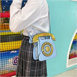 Creative light blue vintage telephone shaped crossbody bag styled with a white shirt and skirt