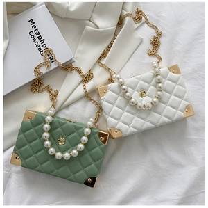 Detail of quilted leather bags with pearl handle and camellia logo on white fabric
