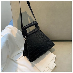 Detail of black faux crocodile texture handbag with unique hollow rectangular handle