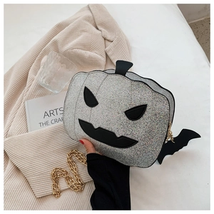 Close-up of silver sequined pumpkin bag with devil face and golden chain for Halloween