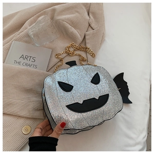 Macro detail of pumpkin bag showing silver sequins and black bat wing decorations