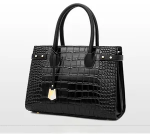Close-up side view of black crocodile pattern handbag with elegant golden hardware details