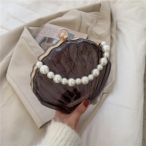 Détail du sac perlé en forme de coquille marron foncé avec poignée en perles chic