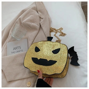 Detail of glitter pumpkin bag with gold chain strap and bat charm for Halloween