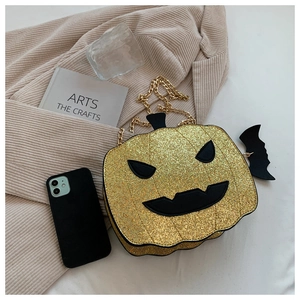 Close-up of sequined pumpkin crossbody bag with gold chain and black bat charm