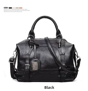 Detail of Boston handbag featuring silver buckles and metallic brand logo plate