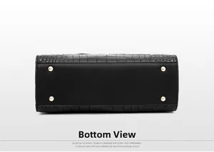 Detailed bottom view of black crocodile pattern handbag with gold protective studs
