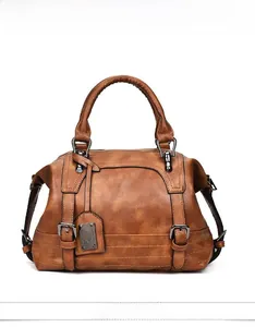 Detailed view of vintage brown Boston bag with textured leather and metal buckles
