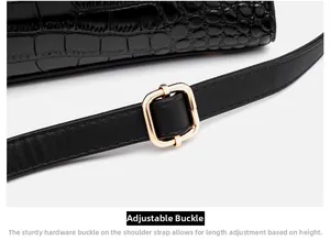 Detail of adjustable shoulder strap with gold metal buckle on black crocodile handbag