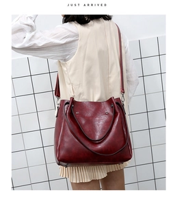 Vista detallada del bolso tote vintage burdeos que muestra el tamaño real y la bandolera